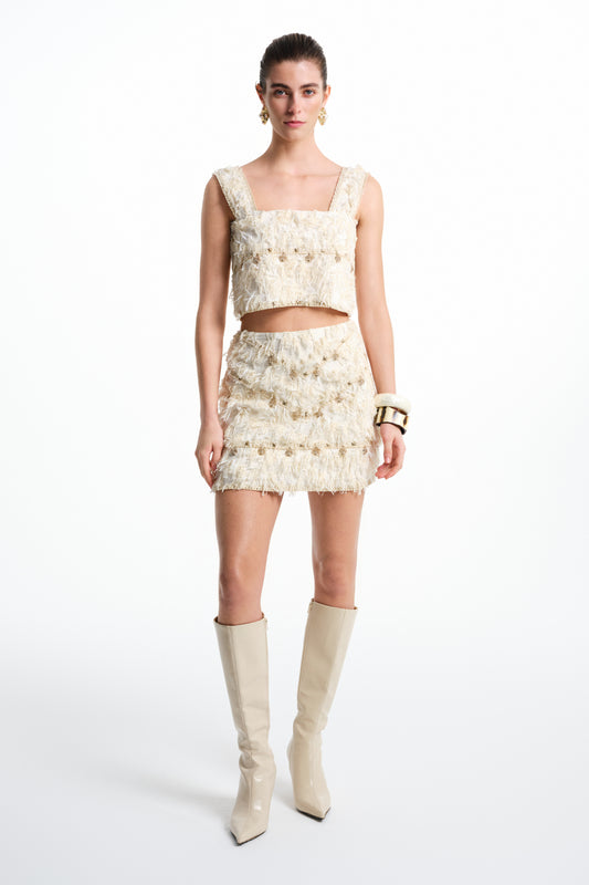 Krem püsküllü kadın crop top, geniş askılı ve aksesuar detaylı